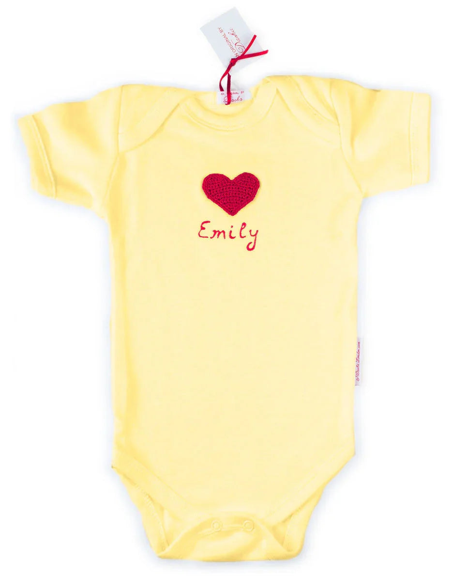 Yellow Norvella baby onesie featuring a red crocheted heart and the name Emily in 3D paint.