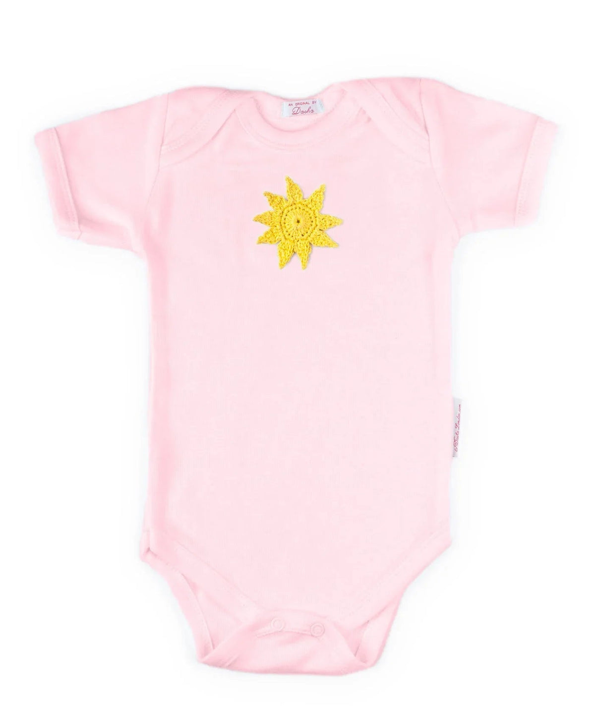 Pink Norvella baby onesie featuring a hand-crocheted yellow sun design.